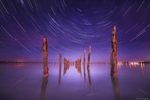 Poles in the water at night on a background star trails