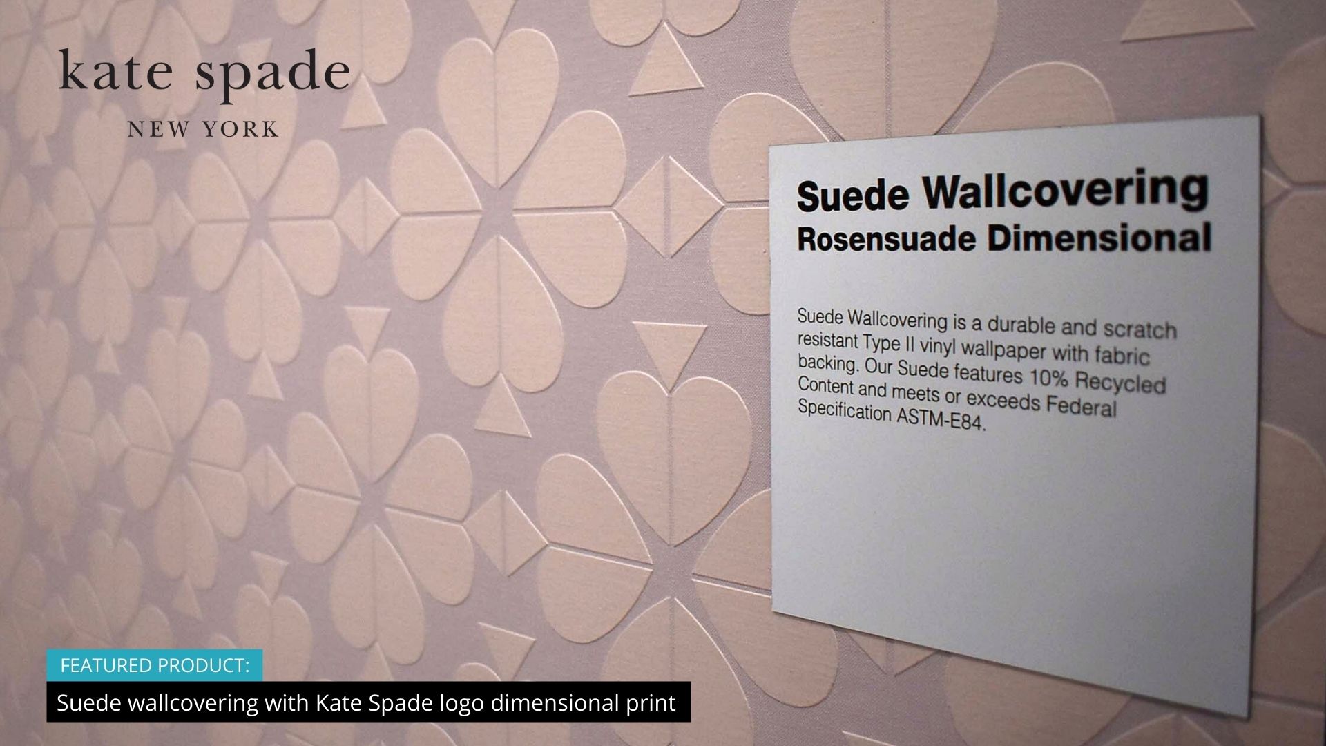 Photo of a closeup of pale pink suede textured wallpaper made up of a seamless pattern created from the Kate Spade logo