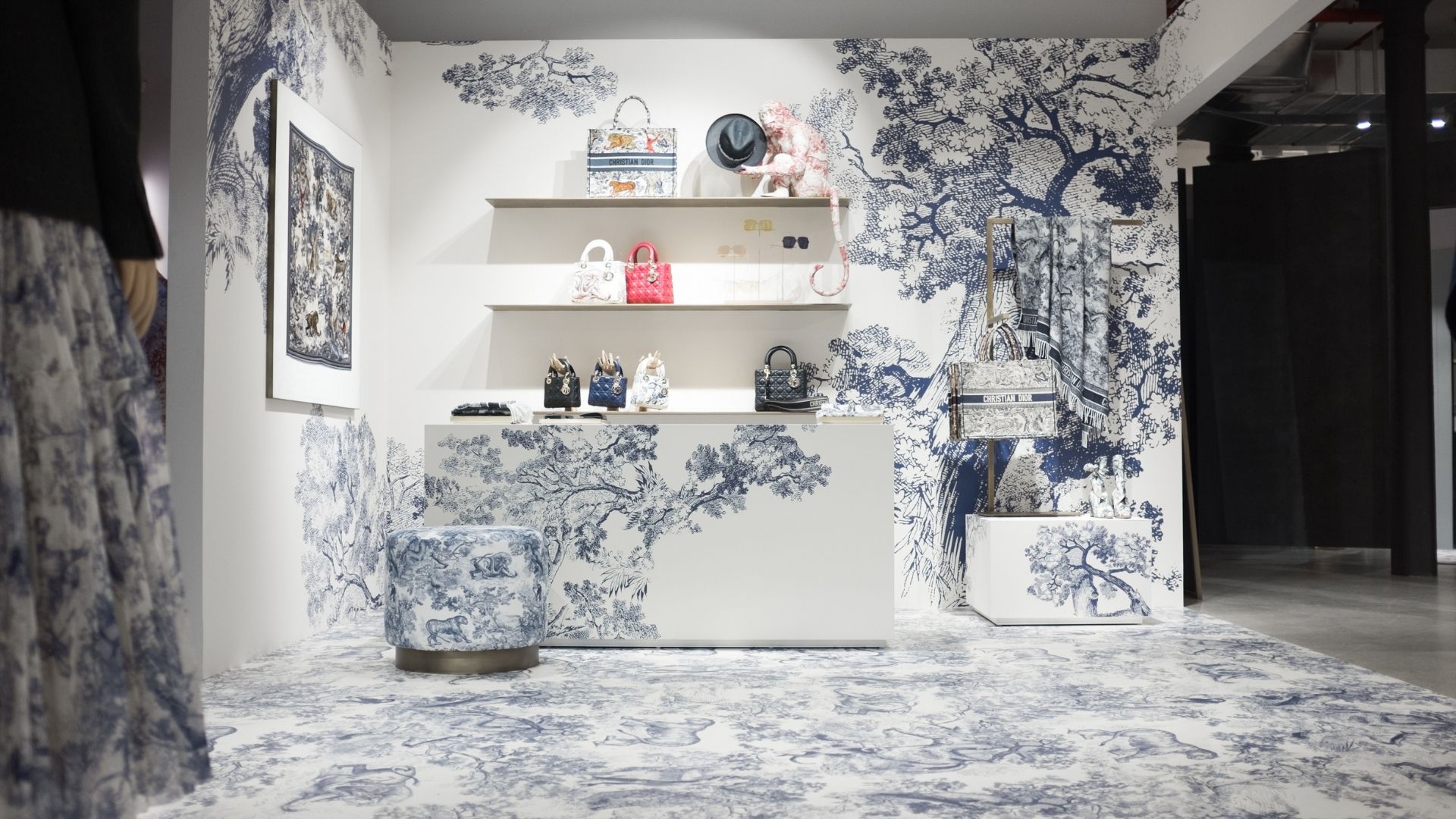 Photo of a Christian Dior fashion retail display with wall-to-wall matching large format installation of blue floral pattern all over the floor, ceiling, walls, tables, and cushions.